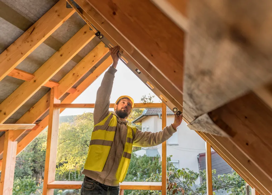Charpentier sur le toit d'une maison en construction